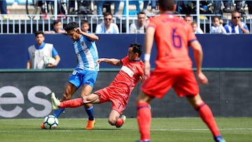 GRAF9965. M&Aacute;LAGA, 22/04/2018.- El delantero de la Real Sociedad Juanmi (c) intenta robarle el bal&oacute;n al defensa venezolano del M&aacute;laga Club de Futbol Roberto Rosales (i) en el partido de la trig&eacute;sima cuarta jornada de LaLiga Sant