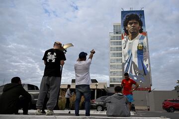 Fans of late Argentine football star Diego Maradona, look at the mural painting by artist Maxi Bagnasco in Canning, outskirts of Buenos Aires.