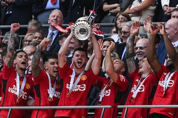 Manchester United's English midfielder #07 Mason Mount lifts the trophy to celebrate their victory at the end of the English FA Cup final 