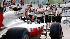 Los miembros del equipo Haas trabajando en el pit lane.