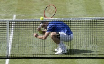 El tenista alemán Philipp Kohlschereiber parece querer esconderse de la pelota detrás de la red durante el partido de cuartos ante el checo Stepanek, en la Mercedes Cup de Sttutgart