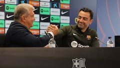 FC Barcelona President Joan Laporta (L) and Barcelona's Spanish coach Xavi react during a press conference at the Joan Gamper training ground in Sant Joan Despi, near Barcelona, on April 25, 2024. Xavi will remain as coach of Barcelona, the Spanish giants told AFP on April 24, despite having announced in January that he planned to quit at the end of the season due to the "cruel and unpleasant" nature of the job. (Photo by LLUIS GENE / AFP)