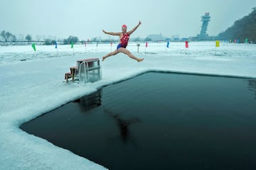 Yu Xiaofeng sonre mientras salta a una piscina tallada en hielo en el ro congelado Songhua, en Harbin, en el noreste de China. Xiaofeng da la imagen de ser una persona alegre y extrovertida, a tenor de los gestos que se aprecian en la fotografa, pero a buen seguro que en cuanto su cuerpo entr en contacto con las glidas aguas le cambi el rictus.