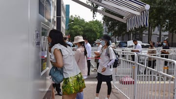 BEIJING, CHINA - 2022/07/29: A health worker takes swab samples from a woman in front of a nucleic acid testing booth. Throat swabs were collected in Beijing as a preventive measure against the spread of covid-19. (Photo by Sheldon Cooper/SOPA Images/LightRocket via Getty Images)