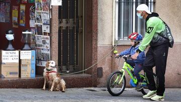 Imagen de un hombre caminando junto a su hijo (que va en bicicleta) por las calles de Terrassa.