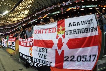 Aficionados del Manchester United. Bandera en memoria de las víctimas del ataque terrorista en el concierto de Ariana Grande.