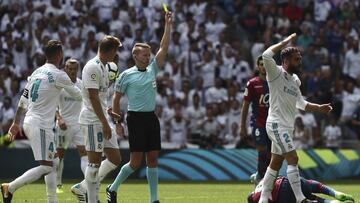 El árbitro Alejandro Hernández Hernández (c) saca tarjeta amarilla al jugador del Real Madrid Daniel Carvajal