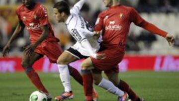 El centrocampista del Valencia Juan Bernat (c) trata de escapar entre David Timor (d) y el belga Roland Lamah (i), ambos de Osasuna, durante el partido de vuelta de los octavos de final de la Copa del Rey que se est&aacute; disputando esta noche en el estadio de Mestalla, en Valencia. 