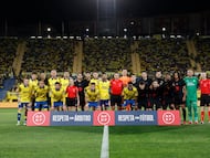 Las plantillas de Las Palmas y Barcelona con un lema de apoyo a los árbitros.