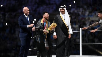 LUSAIL CITY, QATAR - DECEMBER 18: Lionel Messi of Argentina holds the FIFA World Cup Qatar 2022 Winner's Trophy as he interacts with Gianni Infantino, President of FIFA, and Sheikh Tamim bin Hamad Al Thani, Emir of Qatar