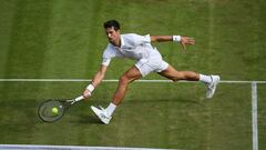 Novak Djokovic se estira para devolver una pelota en Wimbledon.