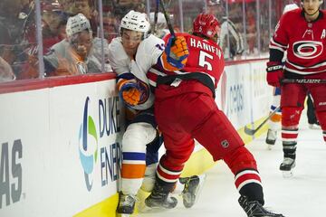 Noah Hanifin de los Carolina Hurricanes bloquea el paso a Mathew Barzal, jugador de los New York Islanders. 