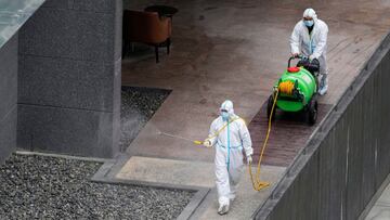 Workers in protective suit spray disinfectant at a community, during the lockdown to curb the spread of the coronavirus disease (COVID-19) in Shanghai, China, April 5, 2022. REUTERS/Aly Song