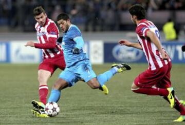 El defensa argentino del Atlético de Madrid, Emiliano Insúa (i) y el delantero Raúl García (d) luchan por el balón con el delantero brasileño Hulk (c) del Zenit de San Petersburgo durante el partido correspondiente a la fase de grupos de la Liga de Campeones disputado en el estadio Petrovsky de San Petersburgo