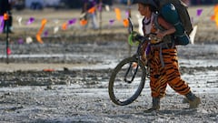 A Burning Man participant walks their bike through the mud near the exit, after a severe rainstorm left tens of thousands of revelers attending the annual festival stranded in mud in Black Rock City, in the Nevada desert September 3, 2023.  Trevor Hughes/USA Today Network via REUTERS.   MANDATORY CREDIT. NO RESALES. NO ARCHIVES
