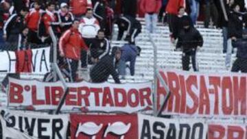 <b>BATALLA CAMPAL. </b>La policía se protege de los objetos lanzados por los aficionados de River, fuera de sí por el descenso.