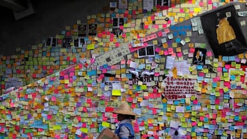 FILE PHOTO: A worker walks past post-it notes scribbled with messages, left behind by protesters on the walls of the Legislative Council, a day after protesters broke into the building, in Hong Kong, China July 2, 2019.  REUTERS/Jorge Silva/File Photo To match Special Report HONGKONG-PROTESTS/PROTESTERS