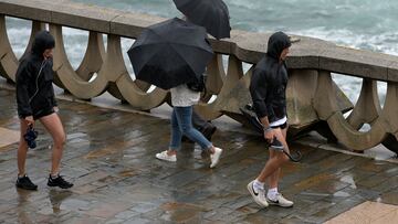 Varias personas con paraguas caminan por el Paseo Marítimo de La Coruña, a 19 de junio de 2022, en A Coruña, Galicia, (España). La inestabilidad se mantendrá en Galicia al menos hasta la mitad de la semana que viene. A partir de mañana lunes 20 de junio  el descenso térmico será notable, con mínimas de hasta 8 grados. Meteogalicia indica que la bajada de temperaturas dejará valores máximos de 30 grados en Ourense y 20º y 21º en A Coruña y Vigo, respectivamente, lo que supone un descenso notable con respecto a las jornadas anteriores.
19 JUNIO 2022;LLUVIA;VIENTO;TEMPORAL;MAL TIEMPO;MAR;OLAS;
M. Dylan / Europa Press
19/06/2022