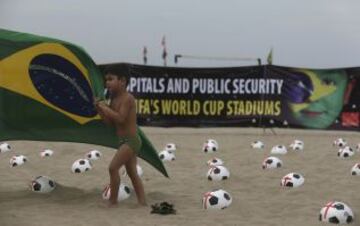 Miembros de la ONG Río de Paz colocan balones de fútbol marcados con cruces rojas como protesta en la playa de Copacabana en Río de Janeiro. La protesta fue un llamado al gobierno para que los servicios de educación, salud pública y para lograr los mismos estándares que los estadios de la Copa Mundial de la FIFA, de acuerdo con la Organización.