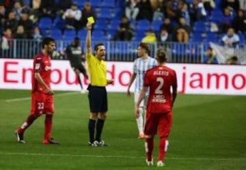 El árbitro Prieto Iglesias  muestra la cartulina amarilla a Alexis, jugador del Getafe.