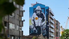 Mural de O Marisqui&ntilde;o pintado en la calle Coru&ntilde;a de Vigo (Galicia, Espa&ntilde;a), de un tipo con sudadera y el logo del festival en la cara, con una tabla de skate bajo el brazo. 