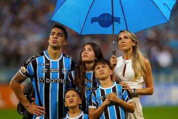 Gremio's Uruguayan forward Luis Suarez (L) his wife Sofia Balbi (R) and their children watch a video in his honour at the end of the Brazilian Championship football match between Gremio and Vasco da Gama at the Arena do Gremio stadium in Porto Alegre, Brazil, on December 3, 2023. Uruguay's 36-year-old record goalscorer Luis Suarez plays his last home game for Gremio on Sunday against Vasco da Gama and will be playing his very last game for this team on December 6 against Fluminense at Maracana stadium. (Photo by SILVIO AVILA / AFP)