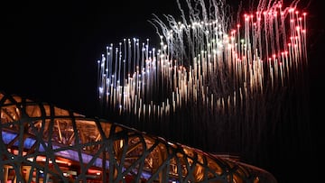 (FILES) A general view of fireworks in the shape of the Olympic Rings light up the sky above the National Stadium, known as the Bird's Nest, during the opening ceremony of the Beijing 2022 Winter Olympic Games in Beijing, on February 4, 2022. Between enchantment and excess, the scenography supervised by Chinese filmmaker Zhang Yimou in 2008, is a demonstration of power and aestheticism to the glory of China, during the Beijing 2022 Olympics Games. (Photo by Jeff PACHOUD / AFP)