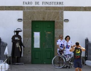 Un par de ciclistas aficionados posar delante del faro de Fisterra en el cuarto día de la 68 edición de "La Vuelta" Vuelta Ciclista a España, una etapa de 189 kilometros entre Lalín y Fisterra / La Etapa del Fin del Mundo