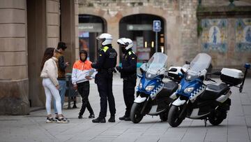 Dos agentes de Polic&iacute;a hablan con tres j&oacute;venes durante el segundo d&iacute;a laborable del estado de alarma por el coronavirus, en Barcelona/Catalunya (Espa&ntilde;a), a 17 de marzo de 2020.