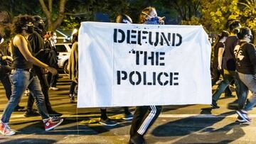 CHICAGO, ILLINOIS - SEPTEMBER 23: A protester carries a sign in support of defunding the police on September 23, 2020 in Chicago, Illinois. Across the country, protesters have taken to the streets after the grand juryx92s decision to only charge one Louis