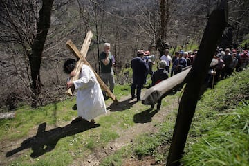 U n hombre porta una cruz en representación de la Subida al Calvario durante el Vía Crucis, en la aldea de Vilar de la parroquia de Villamor, a 7 de abril de 2023, en Folgoso do Courel, Lugo, Galicia, (España). Cada año, por Viernes Santo, numerosos vecinos y visitantes participan en una caminata hasta el entorno de la ermita de San Roque —donde se celebra una representación de la Pasión de Cristo—, deteniéndose sucesivamente en cada una de las estaciones señaladas por las cruces para leer en voz alta una serie de pasajes de los Evangelios. Tras los incendios forestales del pasado verano en Folgoso do Courel se perdieron las cruces de madera que marcan el camino del Vía Crucis de la aldea de Vilar, y la cruz de la escenificación de la crucifixión, Miembros de las organizaciones Fonte do Milagro y Castro Grande han colocado nuevas cruces de madera de castaño que miden unos  2,40 metros y una más pequeña para la persona que interpreta a Cristo.