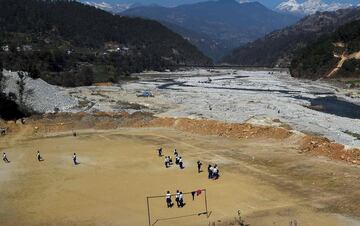 23. Estudiantes de escuelas nepalíes jugando fútbol en un terreno en Bahuneypati, a unos 70 kilómetros al noreste de Katmandú.