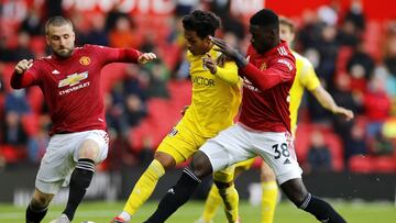 18 May 2021, United Kingdom, Manchester: Fulham&#039;s Fabio Carvalho (C) battles for the ball with Manchester United&#039;s Luke Shaw (L) and Axel Tuanzebe during the English Premier League soccer match between Manchester United and Fulham at Old Traffor