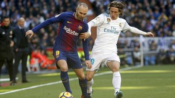 Iniesta se lleva el bal&oacute;n ante Modric.