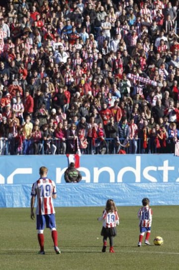 El delantero Fernando Torres, acompañado de sus hijos, saluda a los aficionados durante su presentación como nuevo jugador del Átletico de Madrid, en su regreso cedido hasta el 30 de junio de 2016, esta mañana en el estadio Vicente Calderón