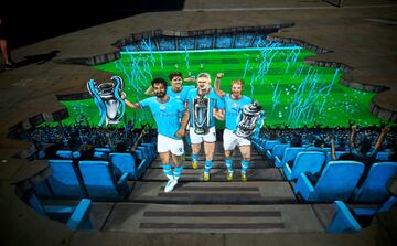 Una original pintura muestra a los jugadores del Manchester City Gündogan, Stones, Haaland y De Bruyne saliendo de las profundidades en New Cathedral Street. La imagen fue tomada antes del desfile en Mánchester como parte de los actos de celebración tras la consecución del triplete (Champions League, Premier League y FA Cup).