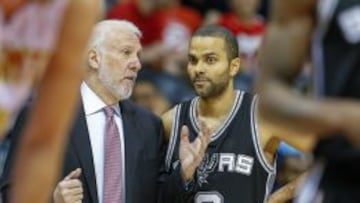 Greg Popovich habla con Tony Parker.