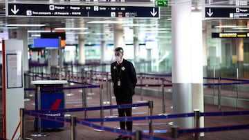A member of Charles de Gaulle airport personnel wears a protective face mask and visor in Terminal 2 of Charles de Gaulle international airport in Roissy near Paris, on May 14, 2020, as France eases lockdown measures taken to curb the spread of the COVID-