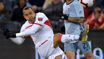Felipe Pardo (L) of Toluca hits the ball as Felipe Gutierrez of Sporting KC looks on during their CONCACAF Champions League game at Children's Mercy Park in Kansas City, Missouri on February 21, 2019. (Photo by Tim Vizer / AFP)