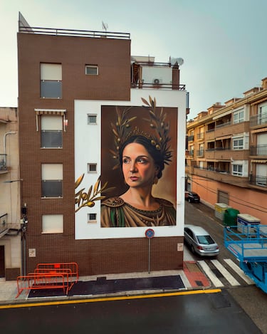 
En Linares, verdes profundos y dorados terrosos coronan a la diosa del olivo. Una presencia serena que perfuma la fachada con la diosa del Mediterráneo.