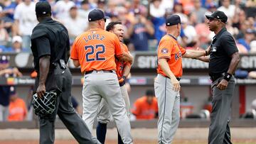 NEW YORK, NEW YORK - JUNE 30: Bench coach Omar Lopez #22 and manager Joe Espada #19 of the Houston Astros get between Jose Altuve #27 and umpires James Jean (L) and Alan Porter after Altuve was ejected from a game against the New York Mets during the seventh inning at Citi Field on June 30, 2024 in New York City.   Jim McIsaac/Getty Images/AFP (Photo by Jim McIsaac / GETTY IMAGES NORTH AMERICA / Getty Images via AFP)