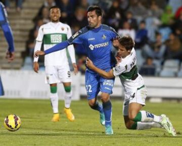 El centrocampista del Getafe Juan Rodríguez (c) lucha un balón con el centrocampista croata del Elche Mario Pasalic (d), durante el partido correspondiente a la undécima jornada de Liga de Primera división que disputan en el estadio Coliseum Alfonso Pérez. 