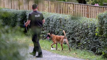 28 July 2020, Lower Saxony, Seelze: A police officer with a dog searches an area inside a garden as part of an investigation plan to find any clues about the disappearance of the British girl Madeleine McCann on 3 May 2007. Photo: Peter Steffen/dpa - ACHT