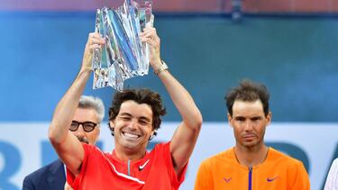Taylor Fritz of the US lifts the championship trophy beside Rafael Nadal of Spain following their ATP Men's Final at the Indian Wells tennis tournament on March 20, 2022 in Indian Wells, California. - Taylor Fritz stunned Rafael Nadal 6-3, 7-6 (7/5) on Su