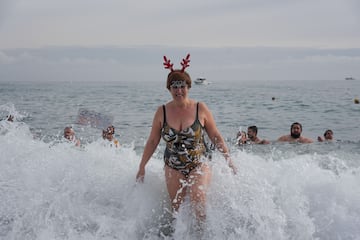 Una mujer con una diadema de cuernos de reno se ba?a en el Mediterr¨¢neo el primer d¨ªa del a?o 2024.
