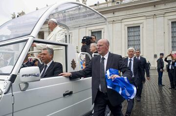 El jefe de la seguridad del papa Francisco, lleva una bandera del Recreativo de Huelva, en la plaza de San Pedro que una delegación del club onubense, le hizo entrega