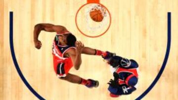 John Wall salta por encima de G-Man, la mascota de los Wizards. 