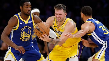 LOS ANGELES, CALIFORNIA - OCTOBER 21: Luka Doncic #77 of the Los Angeles Lakers is trapped by Jonathan Kuminga #1 and Stephen Curry #30 of the Golden State Warriors in the fourth quarter of the game at Crypto.com Arena on October 21, 2025 in Los Angeles, California. NOTE TO USER: User expressly acknowledges and agrees that, by downloading and or using this photograph, user is consenting to the terms and conditions of the Getty Images License Agreement. Harry How/Getty Images/AFP (Photo by Harry How / GETTY IMAGES NORTH AMERICA / Getty Images via AFP)