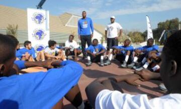 Greg Monroe (de pie), jugador de los Detroit Pistons, junto a varios chicos del campus de baloncesto.