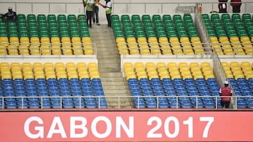 Stewards chat next to empty seats ahead of the 2017 Africa Cup of Nations group A football match between Zimbabwe and Tunisia at the Stade de l'Amitie Sino-Gabonaise in Libreville on January 23, 2017. / AFP PHOTO / GABRIEL BOUYS